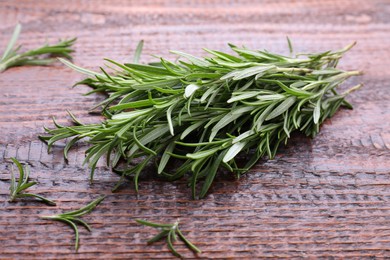 Fresh green rosemary twigs on wooden table, closeup