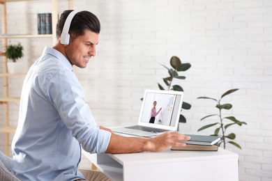 Image of Man watching video at desk indoors. Online learning