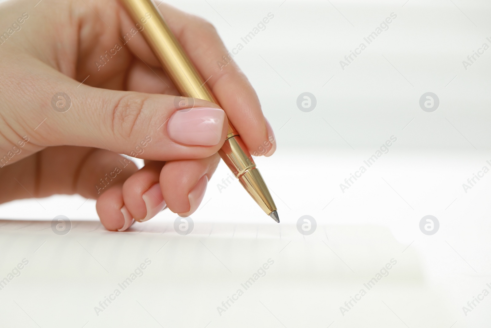 Photo of Woman writing in notebook at white table, closeup