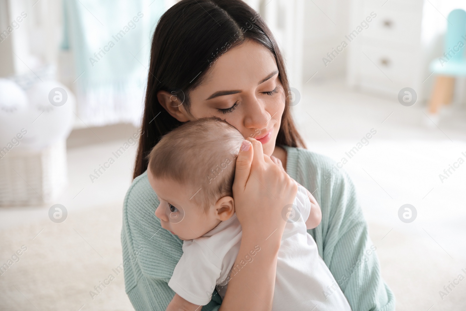 Photo of Young woman with her cute baby at home