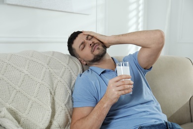 Man taking medicine for hangover at home