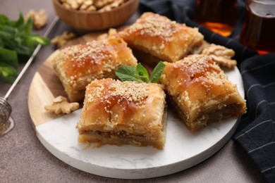 Photo of Eastern sweets. Pieces of tasty baklava on brown table, closeup