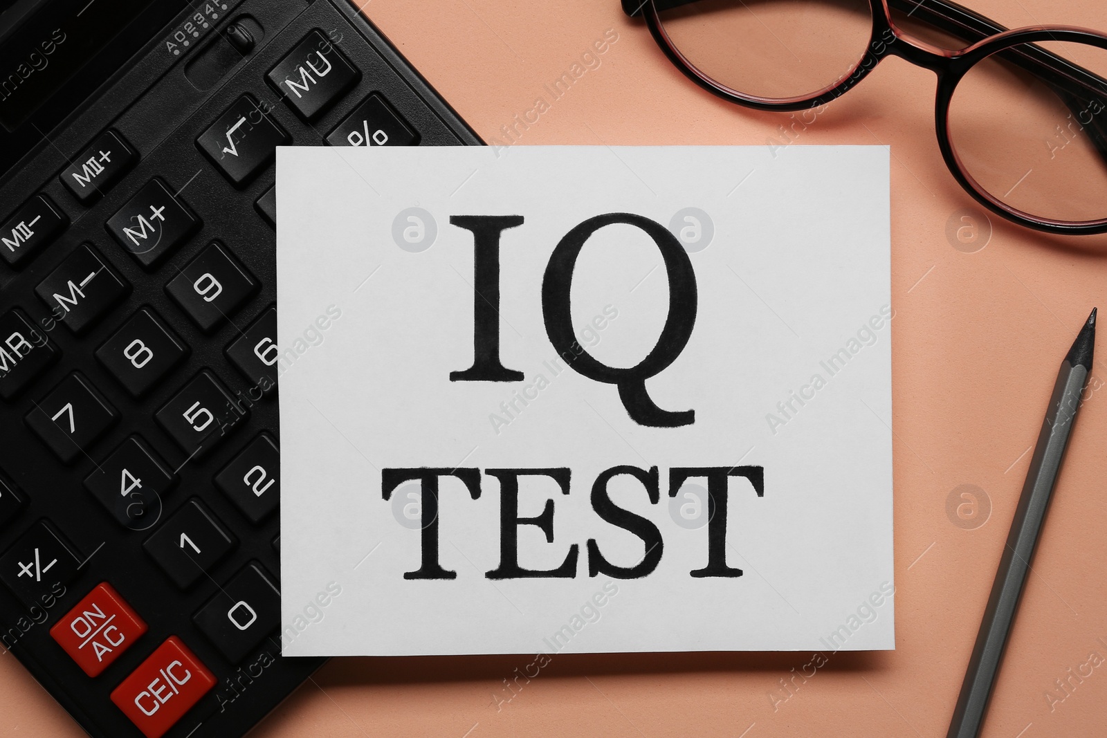 Photo of Note with text IQ Test, calculator, glasses and pencil on coral background, flat lay