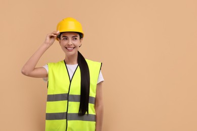 Engineer in hard hat on beige background, space for text