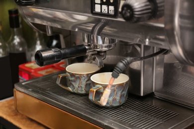 Photo of Preparing fresh aromatic coffee using modern machine at cafe