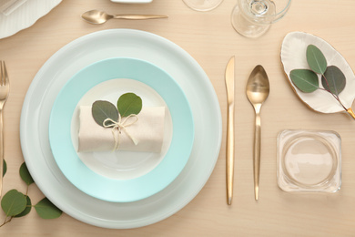 Elegant table setting with green leaves, flat lay