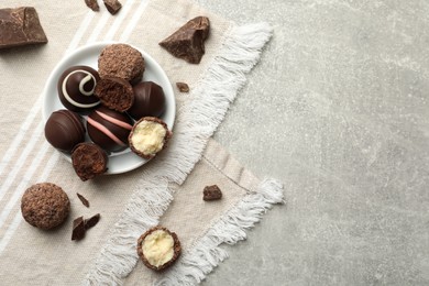 Many different delicious chocolate truffles on light table, top view. Space for text