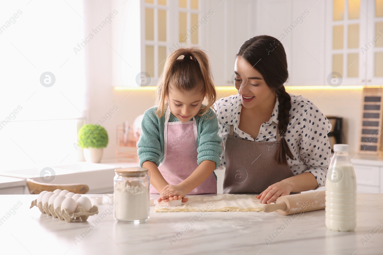 Photo of Mother and daughter making pastry in kitchen at home