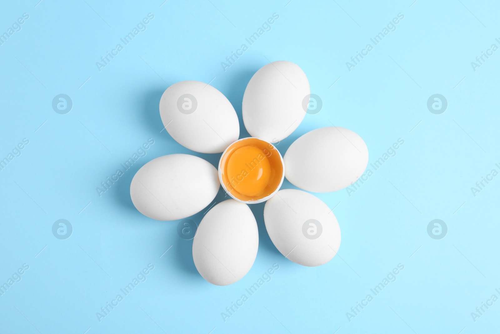 Photo of Fresh raw chicken eggs on light blue background, flat lay