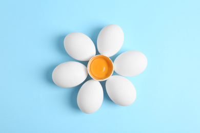 Fresh raw chicken eggs on light blue background, flat lay