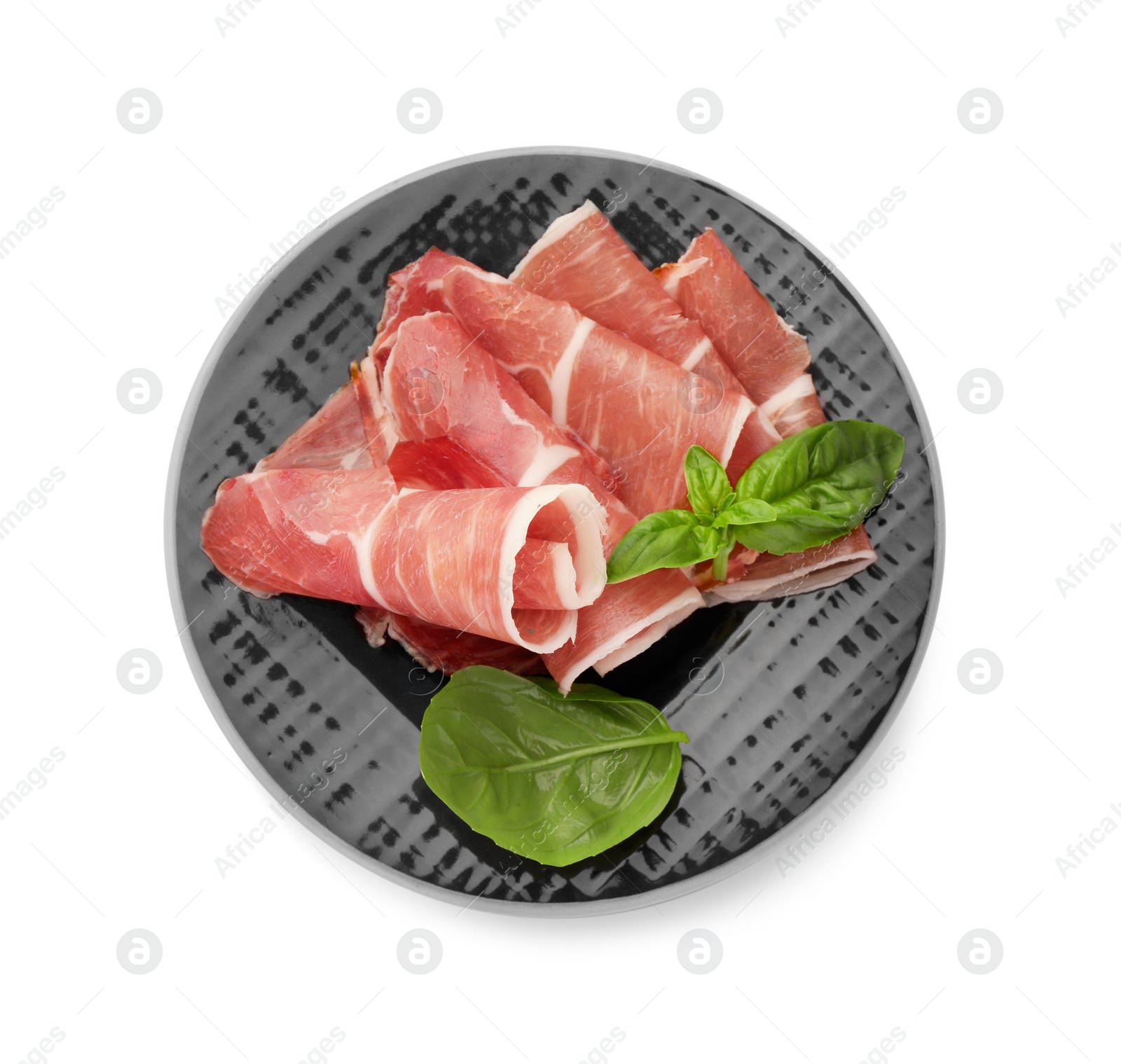 Photo of Plate with rolled slices of delicious jamon and basil isolated on white, top view