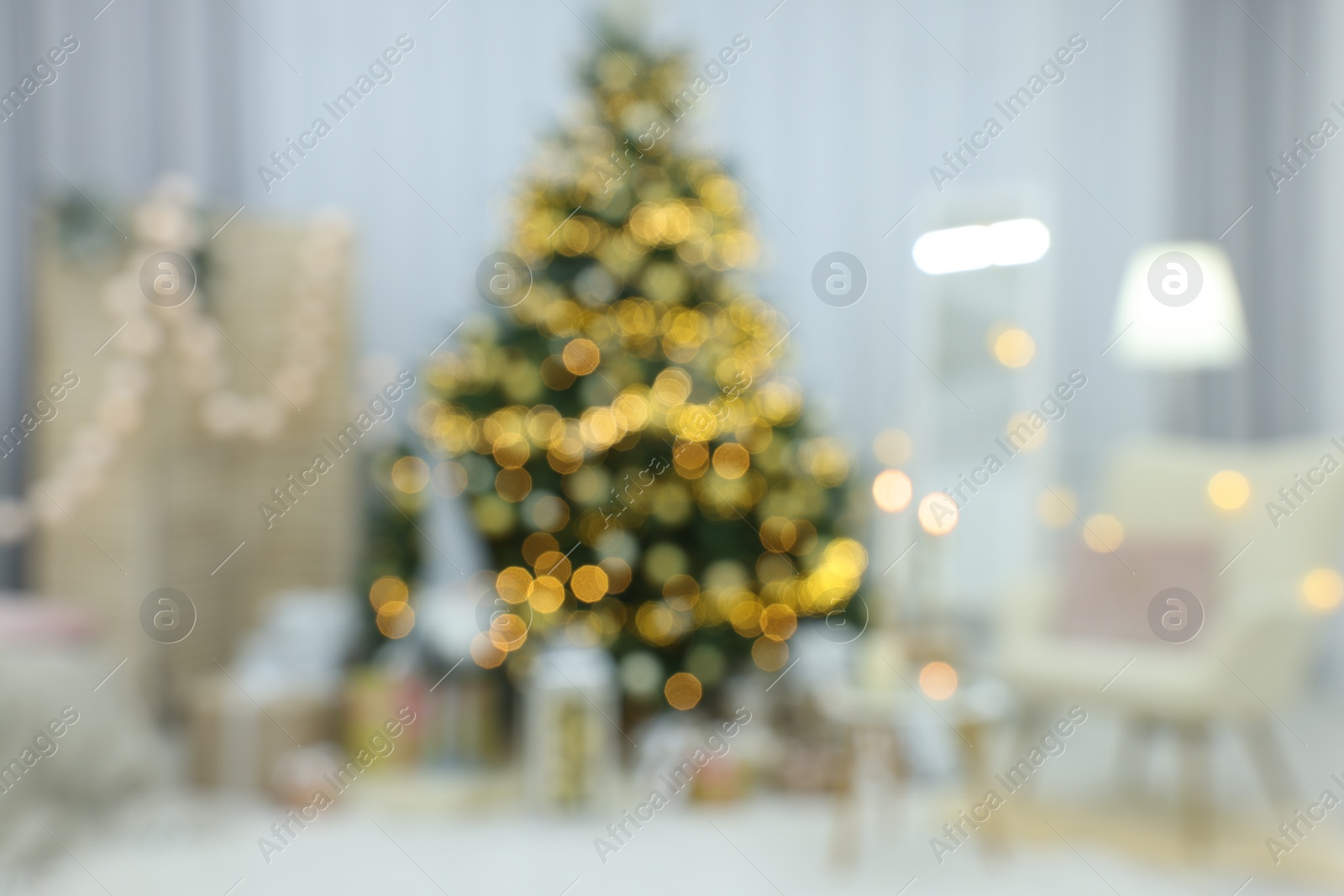 Photo of Blurred view of Christmas tree and festive decor in room. Interior design
