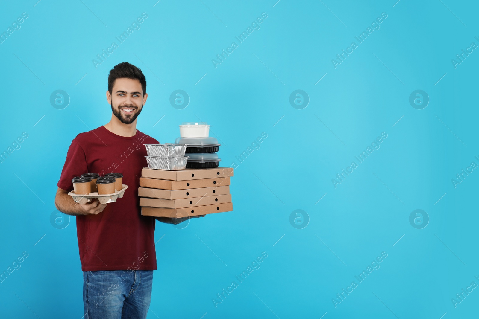 Photo of Young courier with different orders on color background, space for text. Food delivery service