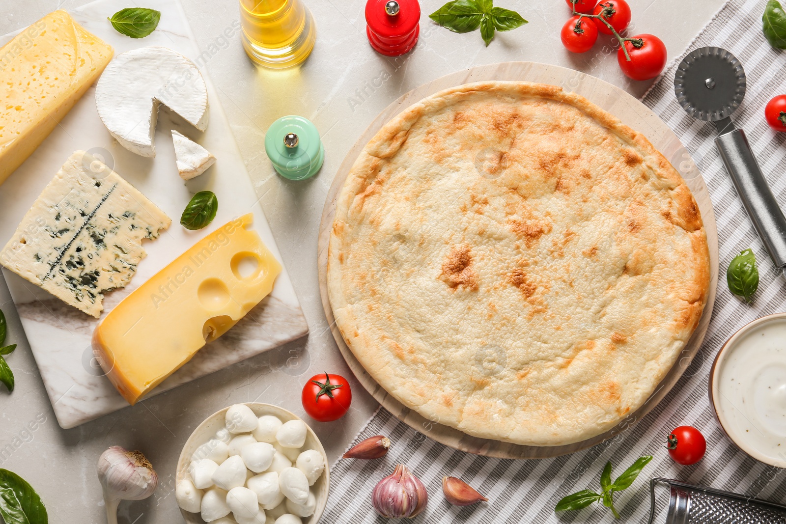 Photo of Flat lay composition with pizza crust and fresh ingredients on light table