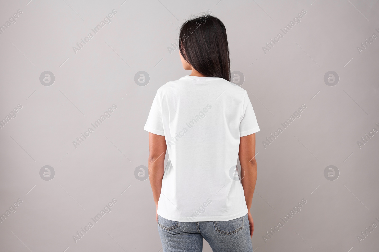 Photo of Woman wearing white t-shirt on light grey background, back view