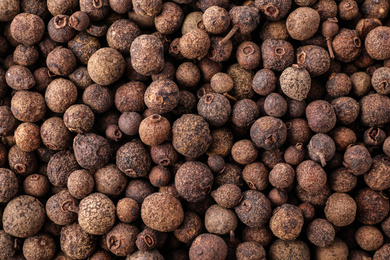 Photo of Black pepper grains as background, top view