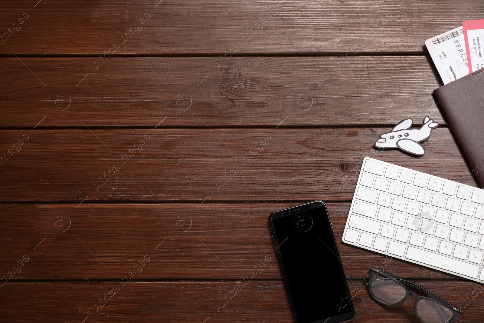 Photo of Flat lay composition with passport, keyboard and smartphone on wooden table, space for text. Business trip