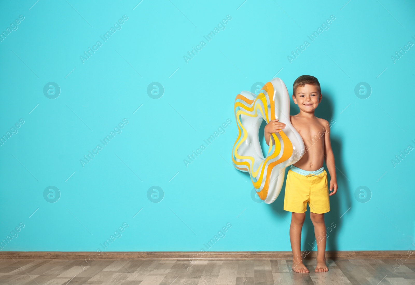 Photo of Cute little boy with inflatable star near color wall