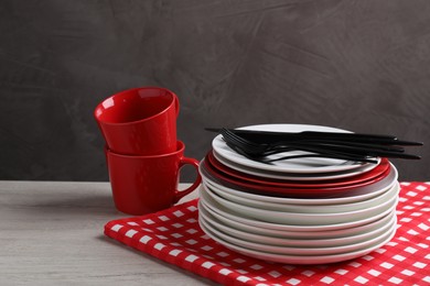 Photo of Set of clean dishware and cutlery on light wooden table