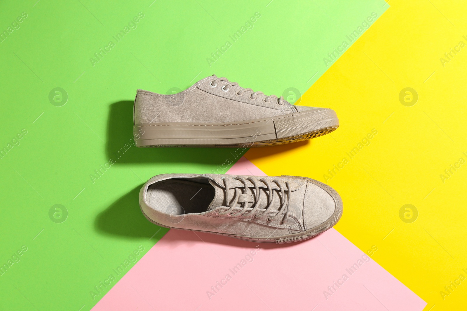 Photo of Pair of stylish sneakers on color background, top view