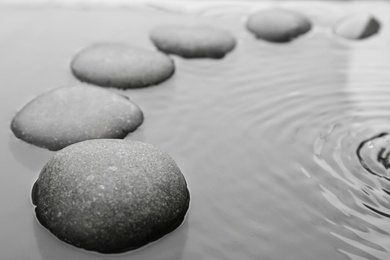 Beautiful spa stones in water, space for text. Zen lifestyle