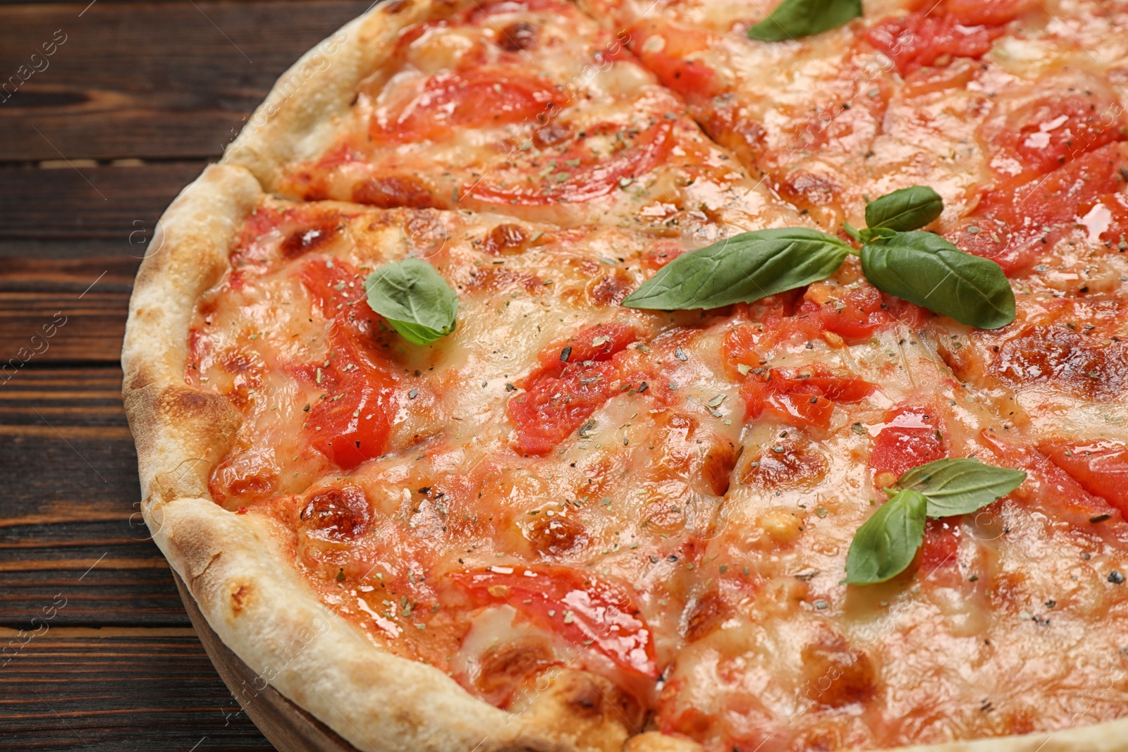 Photo of Delicious pizza Margherita on wooden table, closeup view