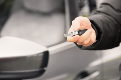 Closeup view of man opening car door with key