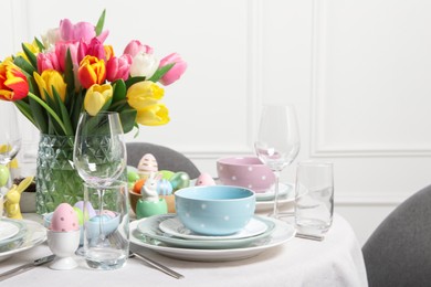 Photo of Easter celebration. Festive table setting with beautiful flowers and painted eggs