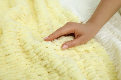 Photo of Woman touching soft yellow fabric, closeup view