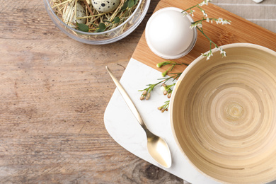 Photo of Rustic Easter table setting with eggs and floral decor, flat lay. Space for text