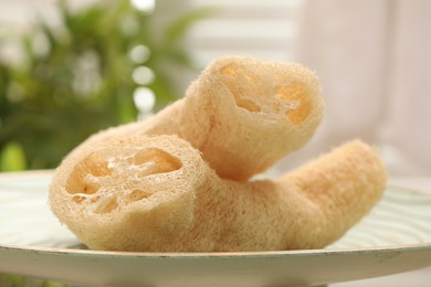 Photo of Loofah sponges on table indoors, closeup. Personal hygiene products