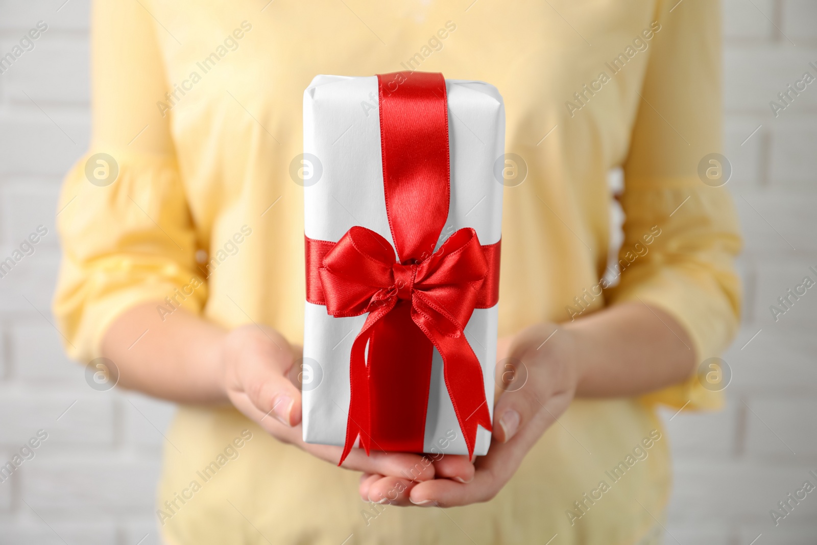 Photo of Woman holding beautiful gift box, closeup