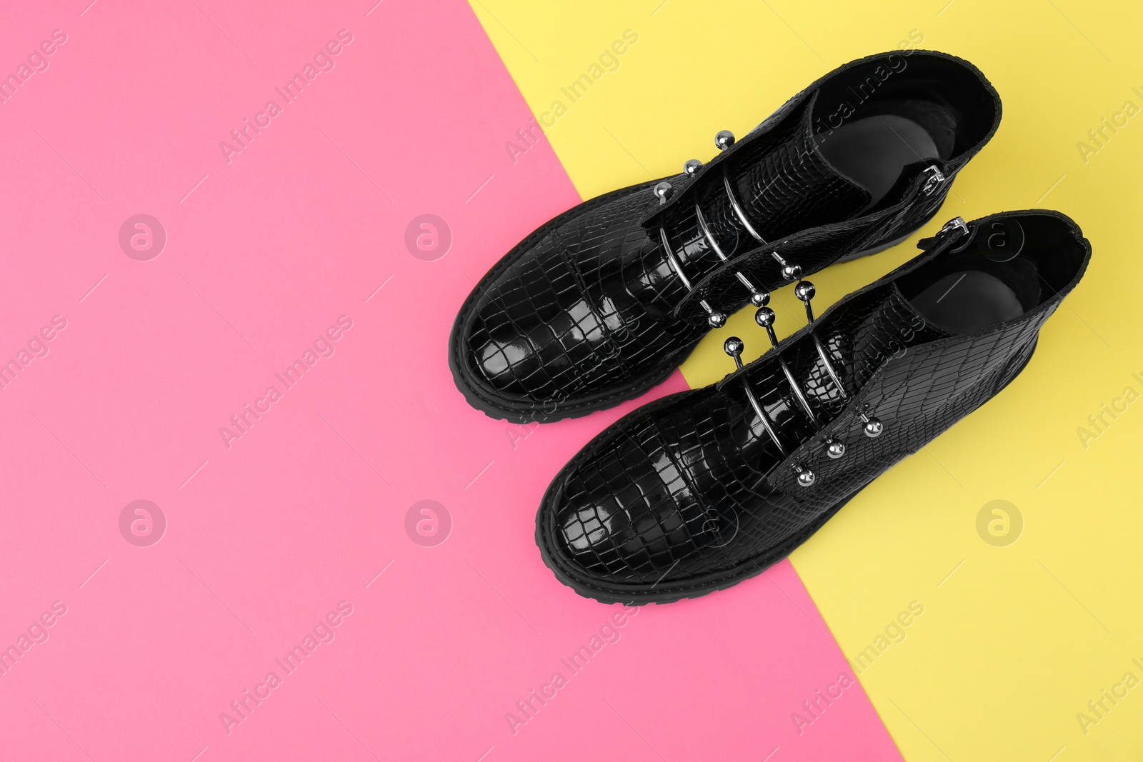 Photo of Pair of stylish ankle boots on color background, top view. Space for text