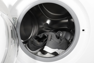 Stylish clean sneakers inside modern washing machine