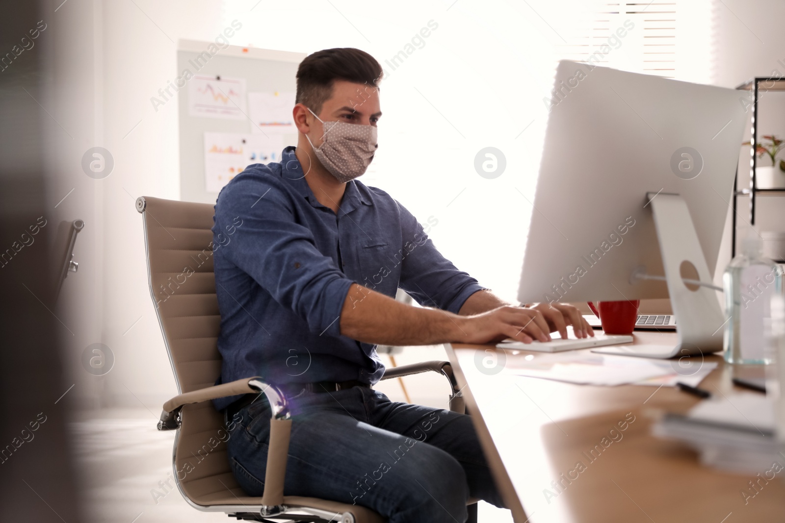 Photo of Worker with mask in office. Protective measure during COVID-19 pandemic