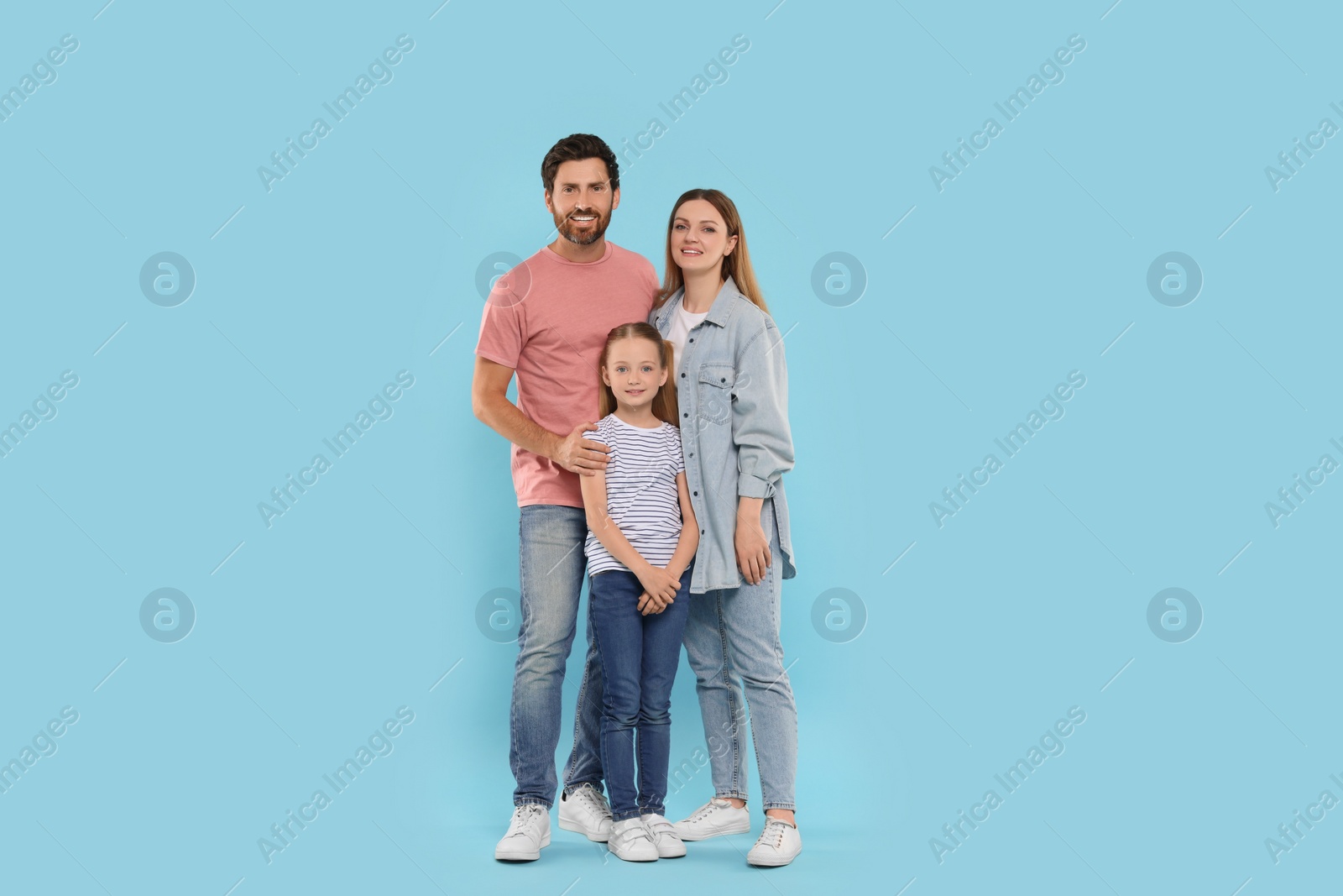 Photo of Happy family together on light blue background