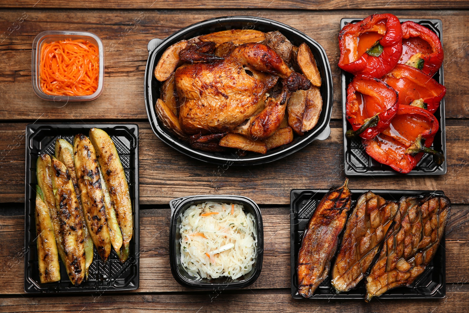 Photo of Plastic containers with different dishes on wooden table, flat lay. Food delivery service