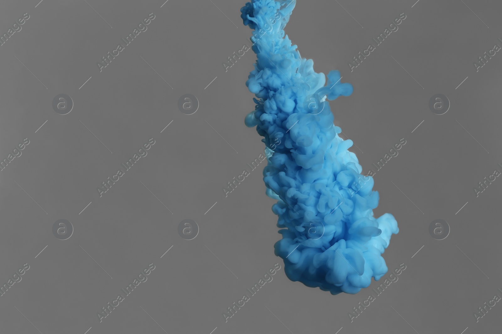 Photo of Splash of blue ink on grey background