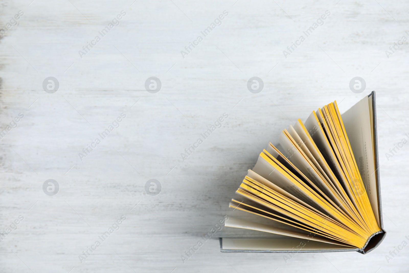 Photo of Hardcover book on white wooden background, top view