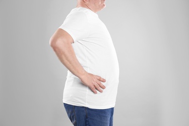 Photo of Fat senior man on grey background, closeup. Weight loss