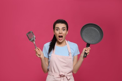 Photo of Emotional housewife with frying pan and spatula on pink background
