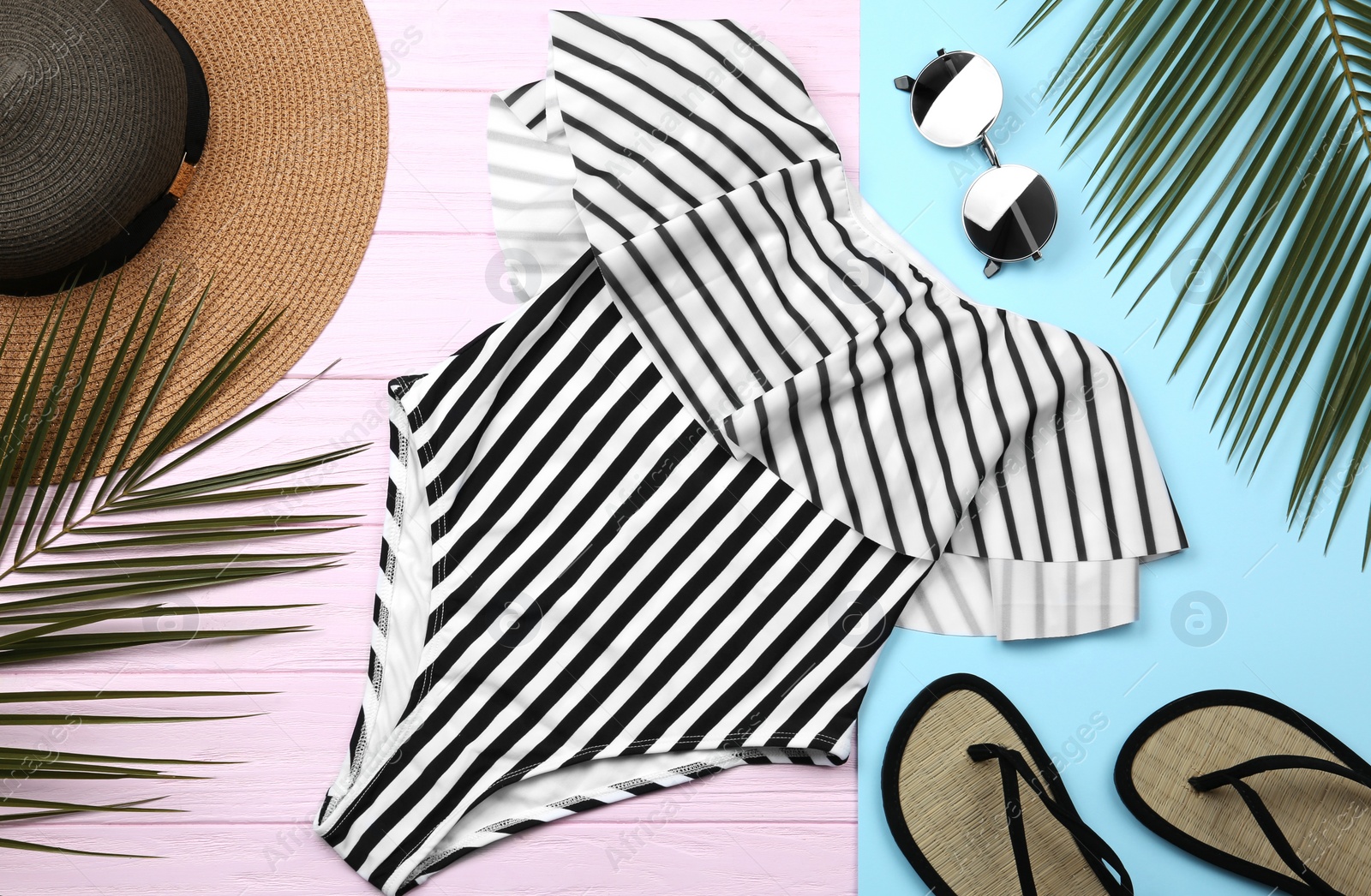Photo of Flat lay composition with striped swimsuit and beach accessories on color background