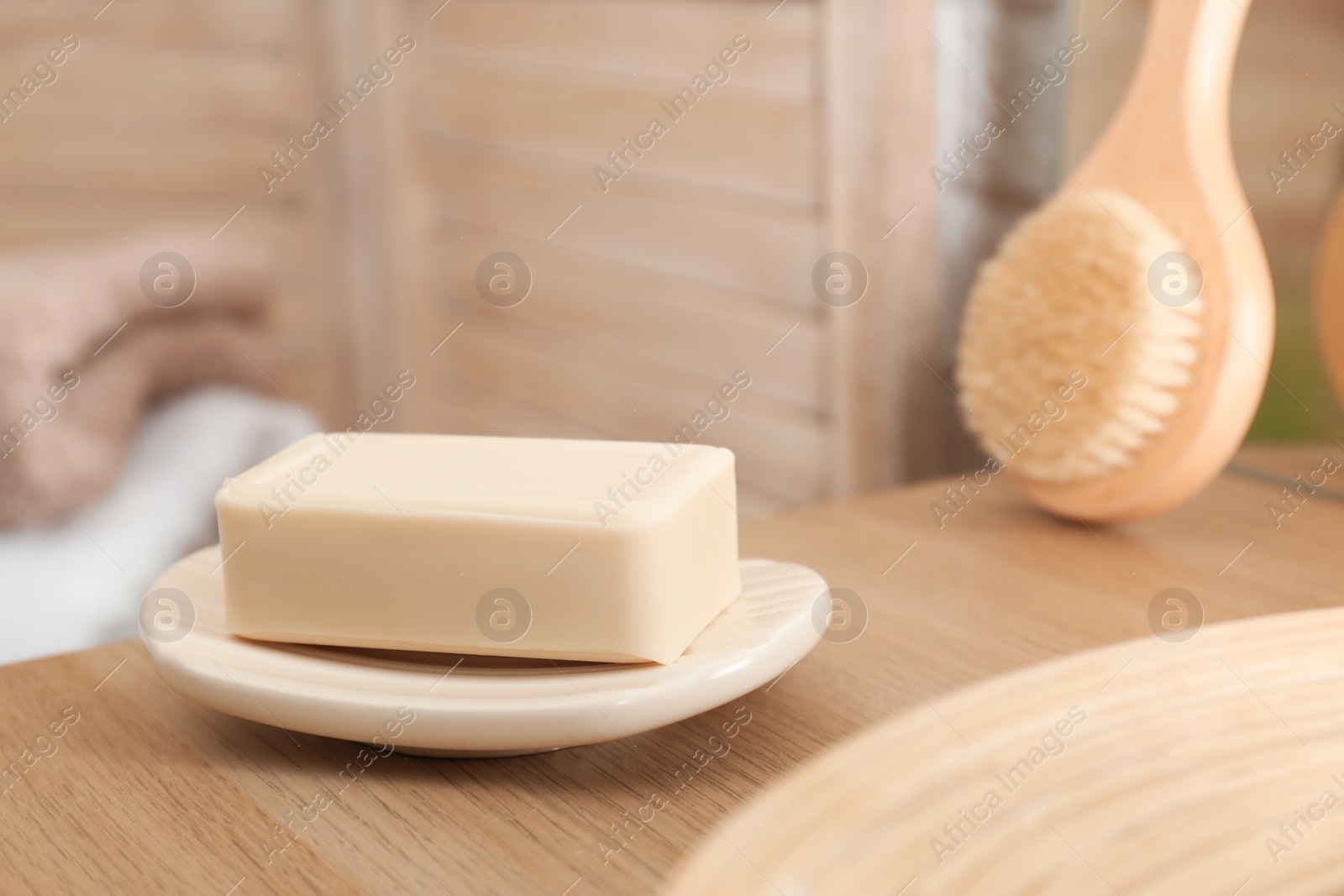 Photo of Dish with soap bar on wooden table. Space for text