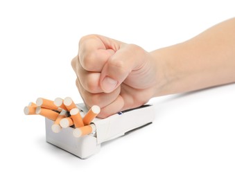 Photo of Stop smoking. Man crushing pack with cigarettes on white background, closeup