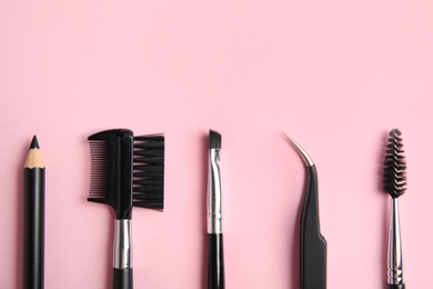 Set of professional eyebrow tools on pink background, flat lay