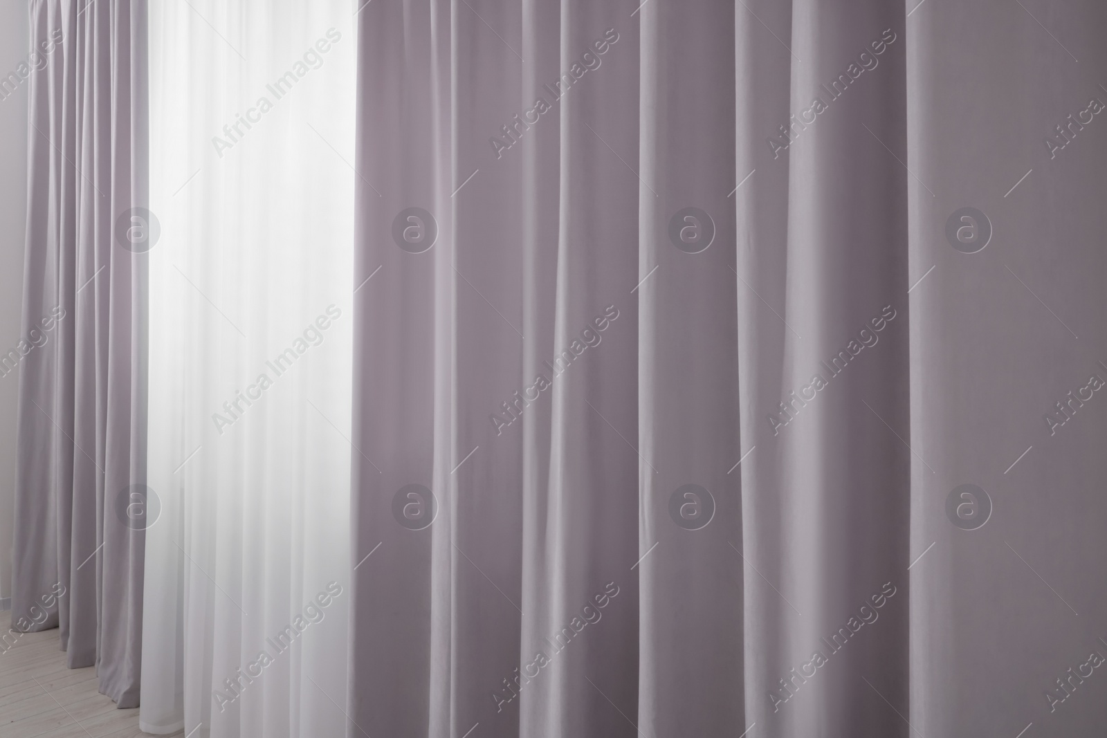 Photo of Light grey window curtains and white tulle indoors