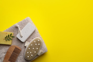 Flat lay composition with pumice stone on yellow background. Space for text