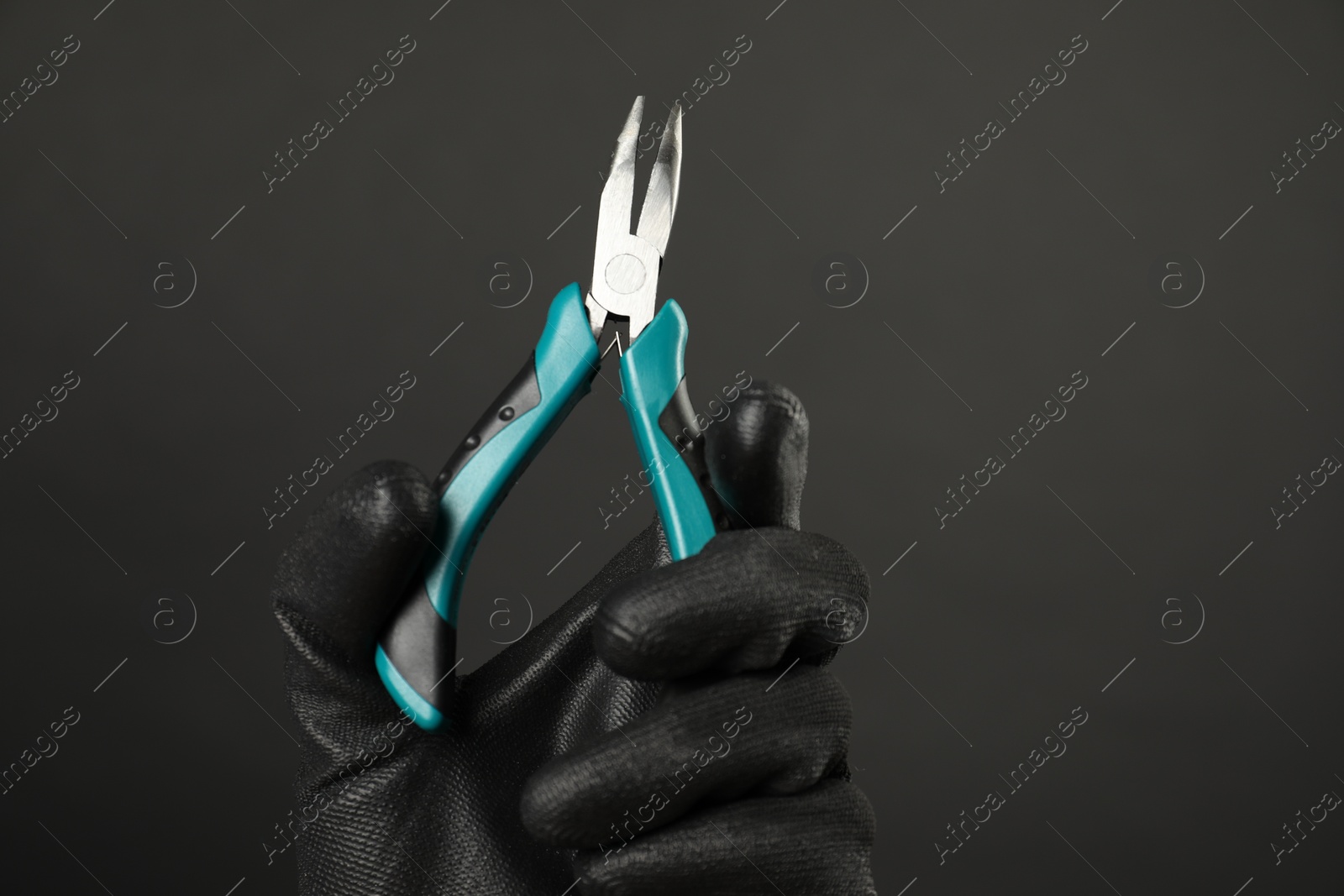 Photo of Woman with bent nose pliers on dark background, closeup