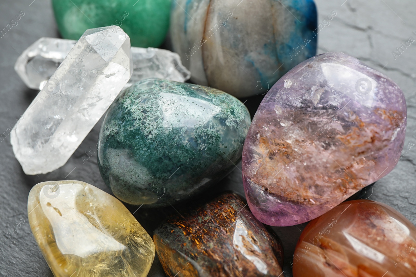 Photo of Different beautiful gemstones on grey background, closeup