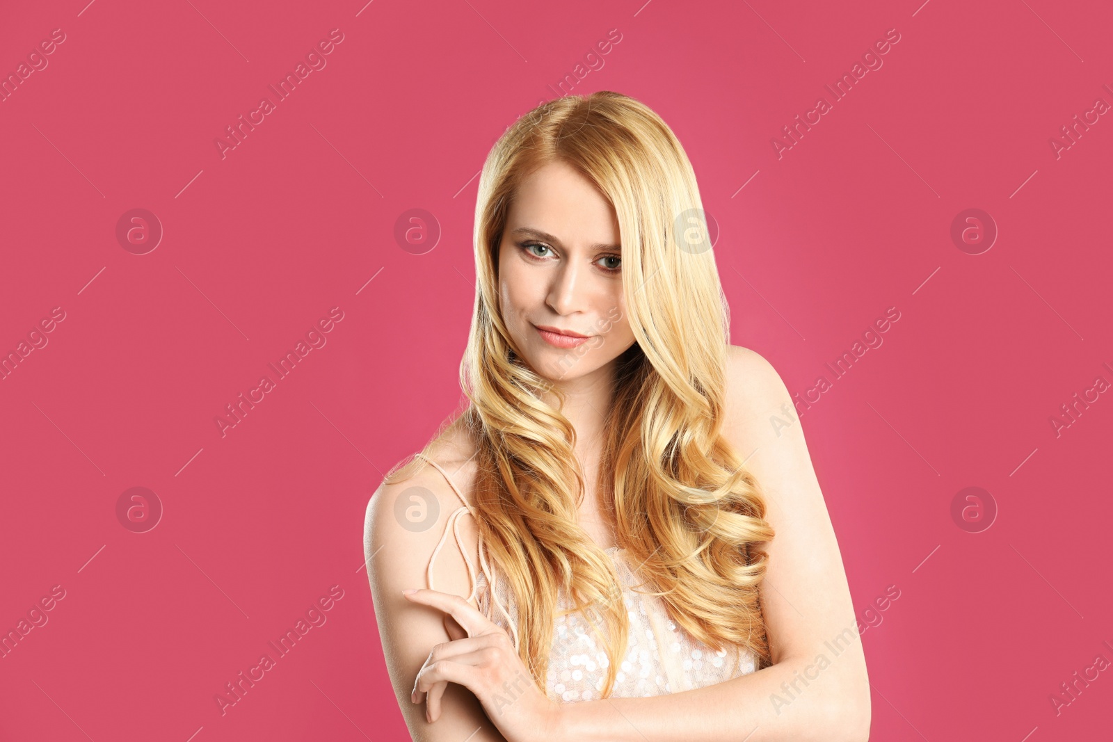 Photo of Portrait of beautiful young woman with dyed long hair on pink background